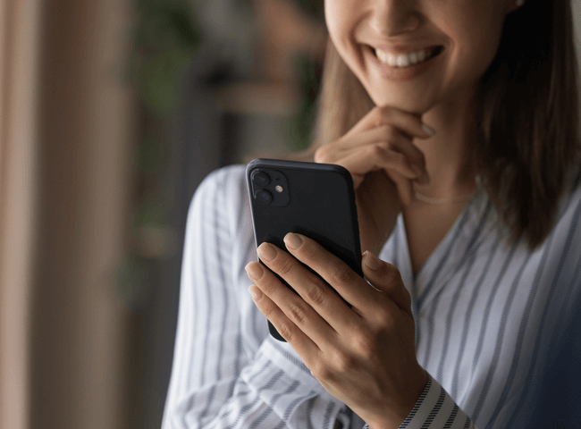 Close up cropped shot of smiling confident young woman enjoy using modern smartphone