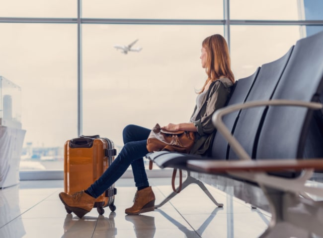 Woman waiting at an airport with her suitcase